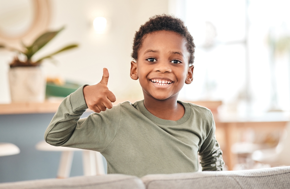 A cheerful child giving a thumbs up, symbolizing positive results from early orthodontic treatment and healthy growing smiles - Phase 1 Orthodontics